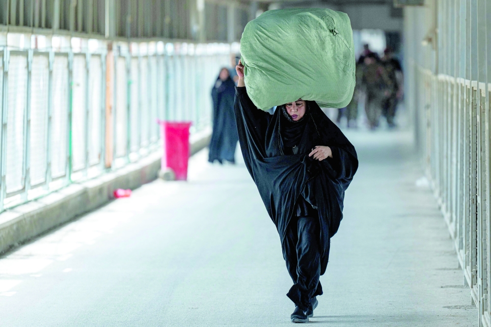 A traveller crosses into Iran at the Shalamjah (Shalamcheh) border crossing with Iran in southeastern Iraq on April 4, 2026. A US-Israeli strike on April 4 hit the border trade terminal, killing one person, according to Iranian media. After the strike, Iraq suspended trade and passenger movement through the crossing, the Iraqi News Agency, quoting the Border Ports Authority chief. (Photo by Hussein FALEH / AFP)

