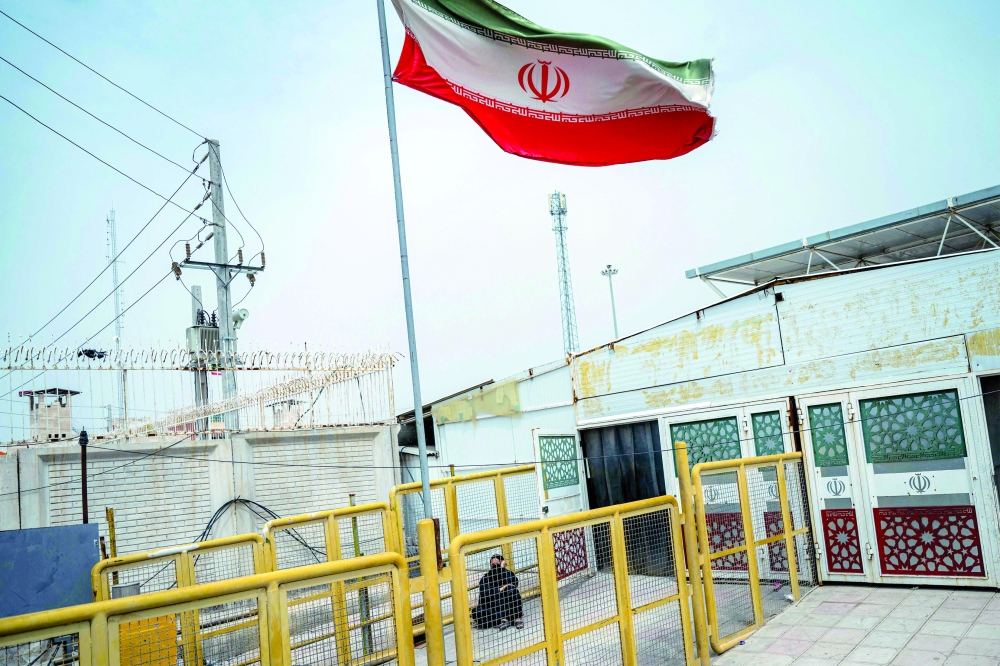 A traveller waits for border procedures to cross back into Iran at the Shalamjah (Shalamcheh) border crossing with Iran in southeastern Iraq on April 4, 2026. A US-Israeli strike on April 4 hit the border trade terminal, killing one person, according to Iranian media. After the strike, Iraq suspended trade and passenger movement through the crossing, the Iraqi News Agency, quoting the Border Ports Authority chief. (Photo by Hussein FALEH / AFP)
