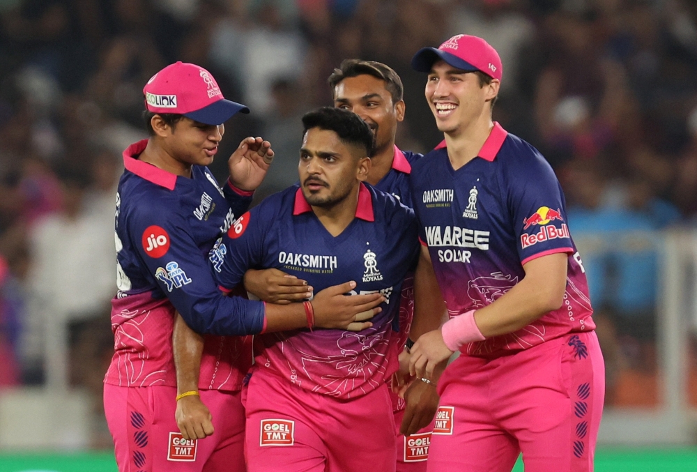  Rajasthan Royals' Tushar Deshpande celebrates with teammates after taking the wicket of Gujarat Titans' Rashid Khan  