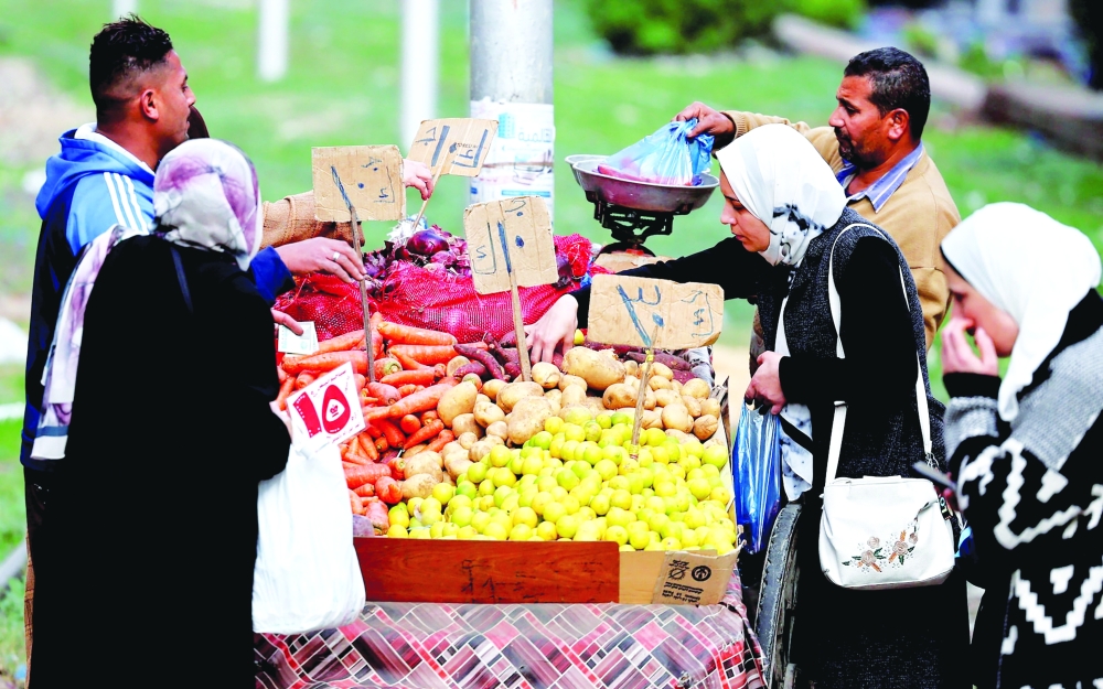 People buy vegetables at a popular market in the Mediterranean city of Alexandria, Egypt. — Reuters