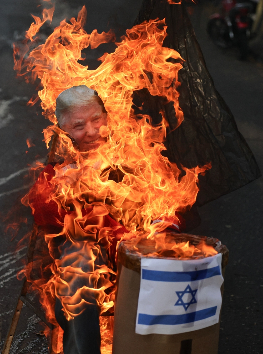 An effigy depicting US President Donald Trump and an Israeli flag burn during the Burning of Judas ritual as part of Easter celebrations on a street in the 23 de Enero neighborhood in Caracas on April 5, 2026.