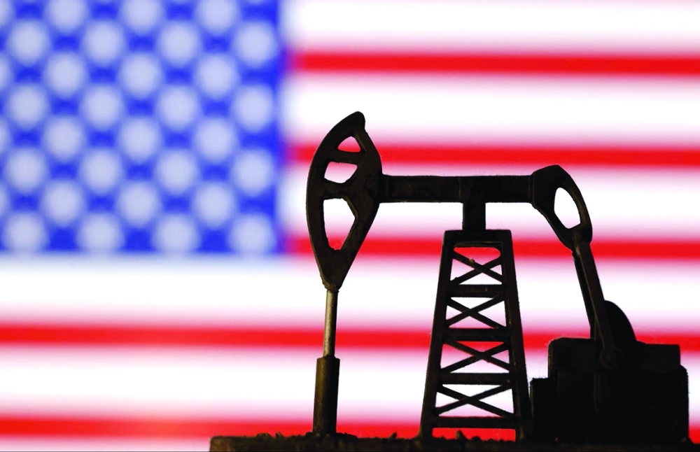 Oil pump jack is seen in front of displayed US flag in this illustration. — Reuters