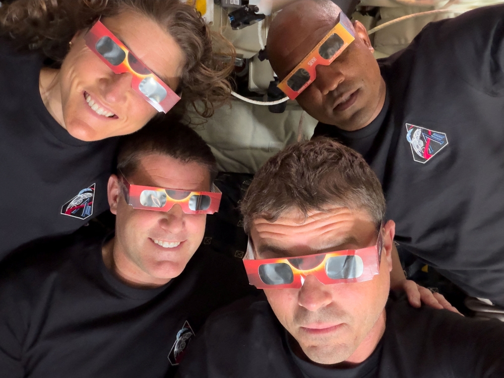 The Artemis II crew of NASA astronauts Christina Koch, Reid Wiseman, Victor Glover and Canadian Space Agency (CSA) astronaut Jeremy Hansen pose with their eclipse glasses used to protect their eyes for the Orion spacecraft's flyby of the Moon April 6, 2026.   Picture taken with a mobile phone.   