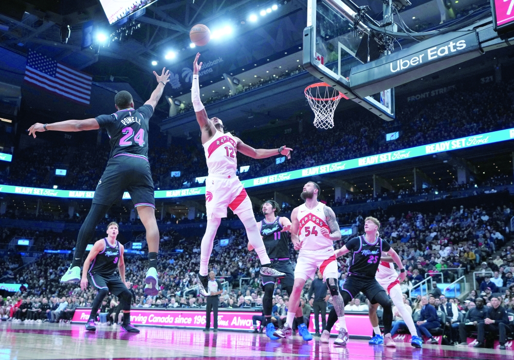 Toronto Raptors' Scottie Barnes (4) battles for the ball with Miami Heat's Norman Powell (24) at Scotiabank Arena. — Imagn Images