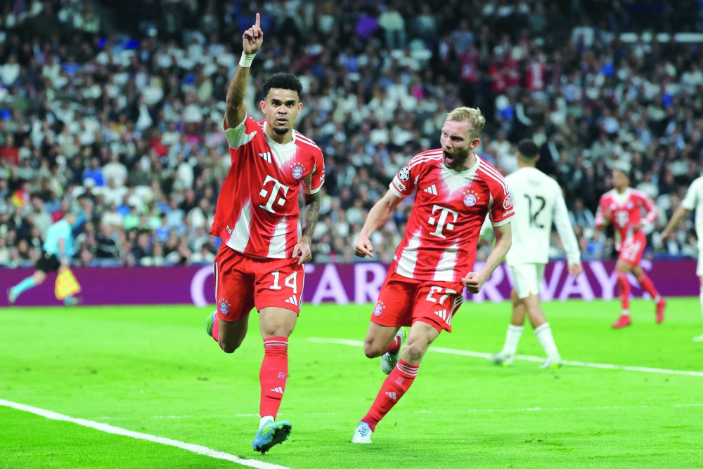 Bayern Munich's Colombian forward #14 Luis Diaz celebrates scoring the opening goal with Bayern Munich's Austrian midfielder #27 Konrad Laimer (R) during the UEFA Champions League quarter final first leg football match between Real Madrid CF and FC Bayern Munich at Santiago Bernabeu Stadium in Madrid on April 7, 2026.  (Photo by Thomas COEX / AFP)