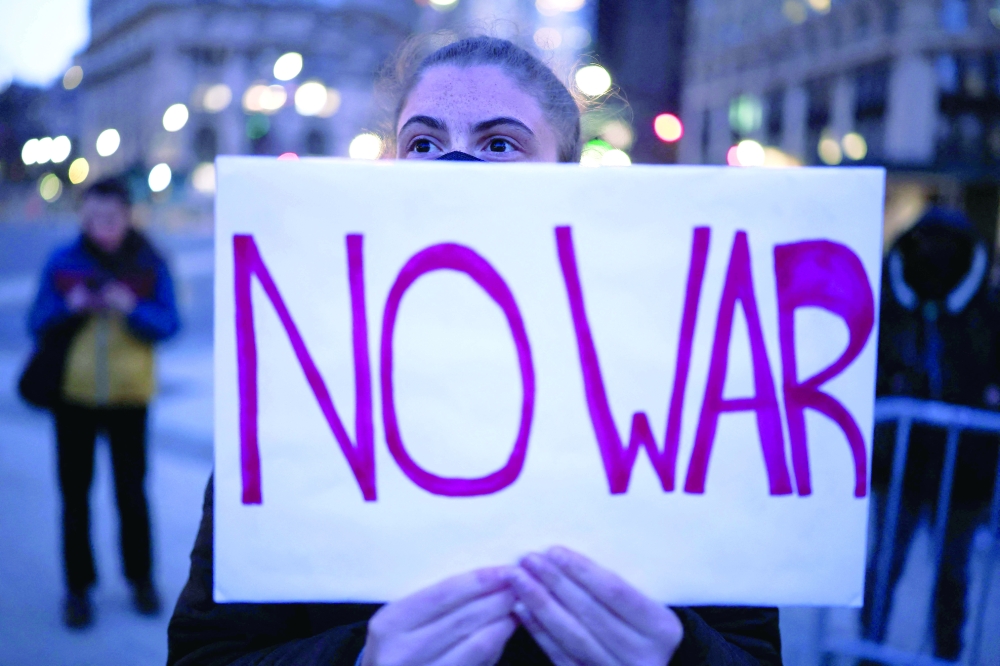 A demonstrator holds a sign during a protest against US military action in Iran in the Manhattan borough of New York City on Wednesday. — AFP