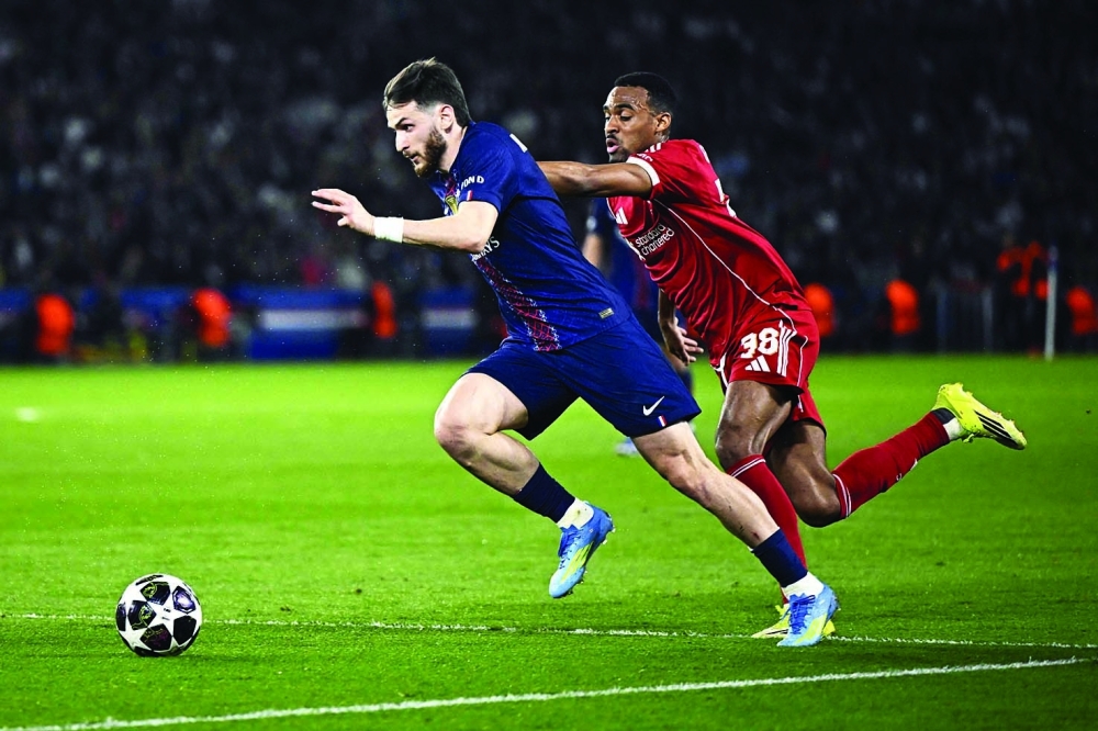 Paris Saint-Germain's Georgian forward #07 Khvicha Kvaratskhelia (L) fights for the ball with Liverpool's Dutch midfielder #38 Ryan Gravenberch during the UEFA Champions League quarter-final first leg football match between Paris Saint-Germain (PSG) and Liverpool FC at the Parc des Princes stadium in Paris on April 8, 2026. (Photo by JULIEN DE ROSA / AFP)
