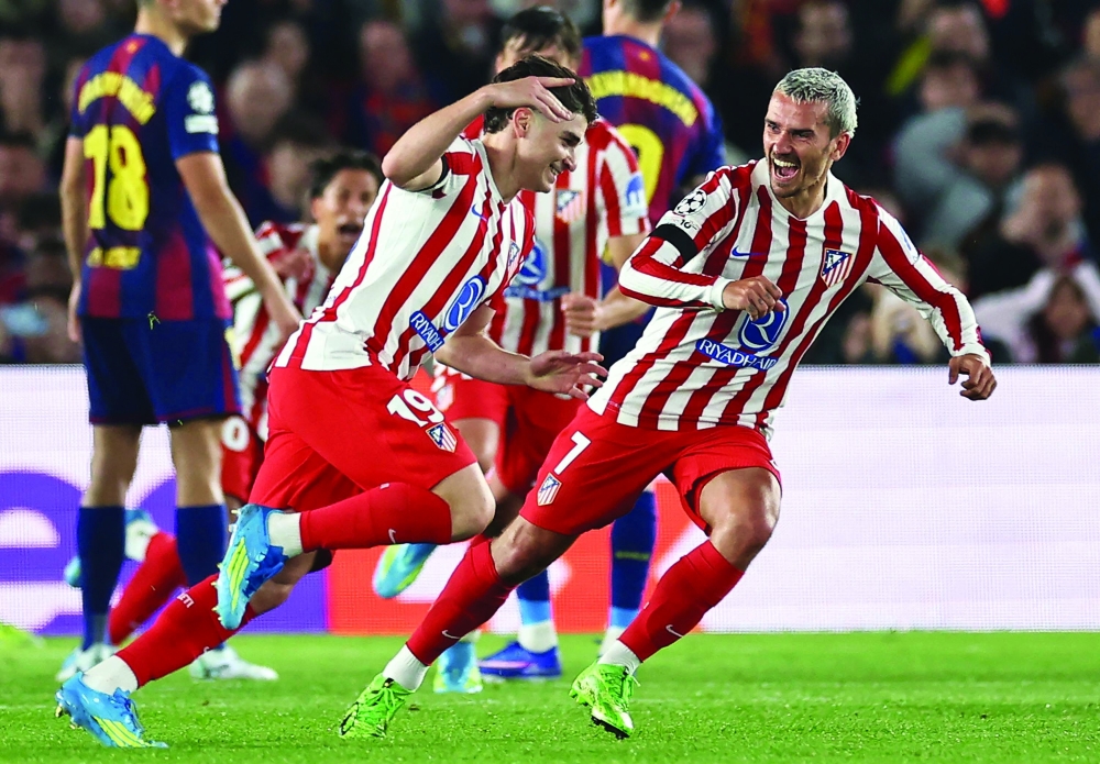 Atletico Madrid's Argentine forward #19 Julian Alvarez celebrates scoring his team's first goal with Atletico Madrid's French forward #07 Antoine Griezmann during the UEFA Champions League quarter final first leg football match between FC Barcelona and Club Atletico de Madrid at Camp Nou Stadium in Barcelona on April 8, 2026.  (Photo by Josep LAGO / AFP)

