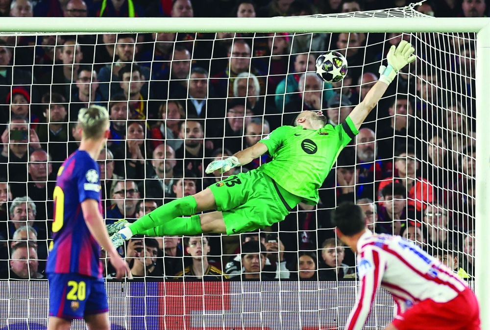 Atletico Madrid's Argentine forward #19 Julian Alvarez (not seen) scores his team's first goal in spite of Barcelona's Spanish goalkeeper #13 Joan Garcia during the UEFA Champions League quarter final first leg football match between FC Barcelona and Club Atletico de Madrid at Camp Nou Stadium in Barcelona on April 8, 2026.  (Photo by Josep LAGO / AFP)
