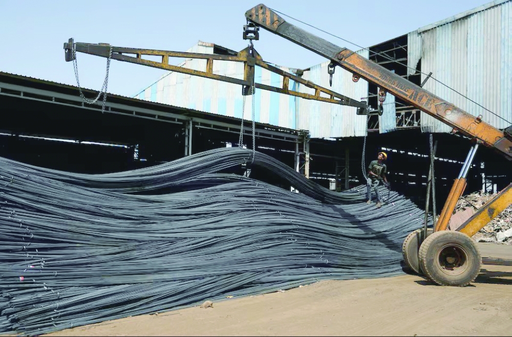 A labourer unloads TMT steel bars from a crane inside a steel bar manufacturing factory at Viramgam, in the western Indian state Gujarat, India Reuters