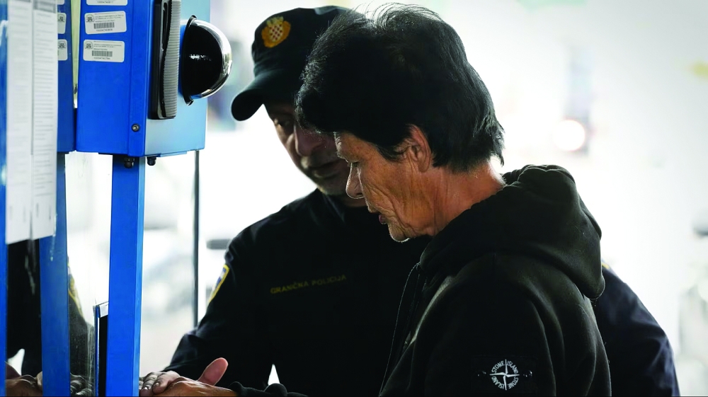 A traveller is assisted by a police officer as she is taken fingerprints at Stara Gradiska border crossing between Croatia and Bosnia and Herzegovina, as the Entry/Exit System (EES) required all non-EU citizens to register their personal details when they first enter the Schengen Area is introduced. — AFP File