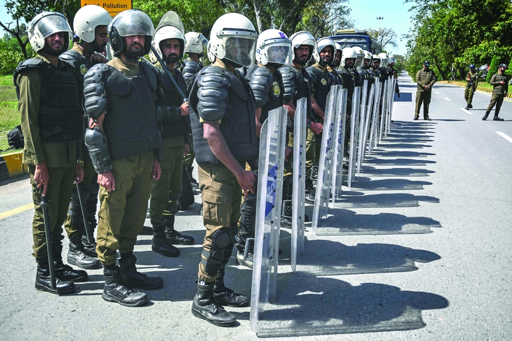 Riot policemen line up along a road near the expected venue of the US-Iran talks in the Red Zone area of Islamabad. — AFP