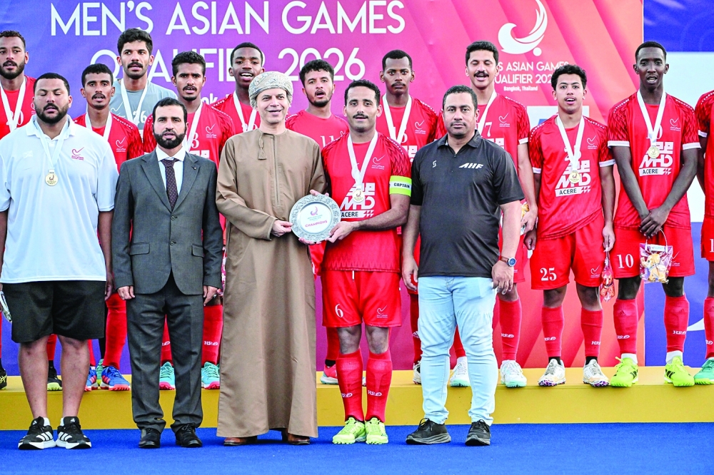 Oman players celebrate with the Asian Games Qualifier champions shield.