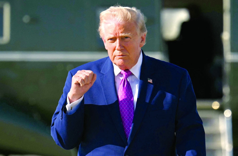 US President Donald Trump gestures after stepping off Marine One at Joint Base Andrews, Maryland. — AFP