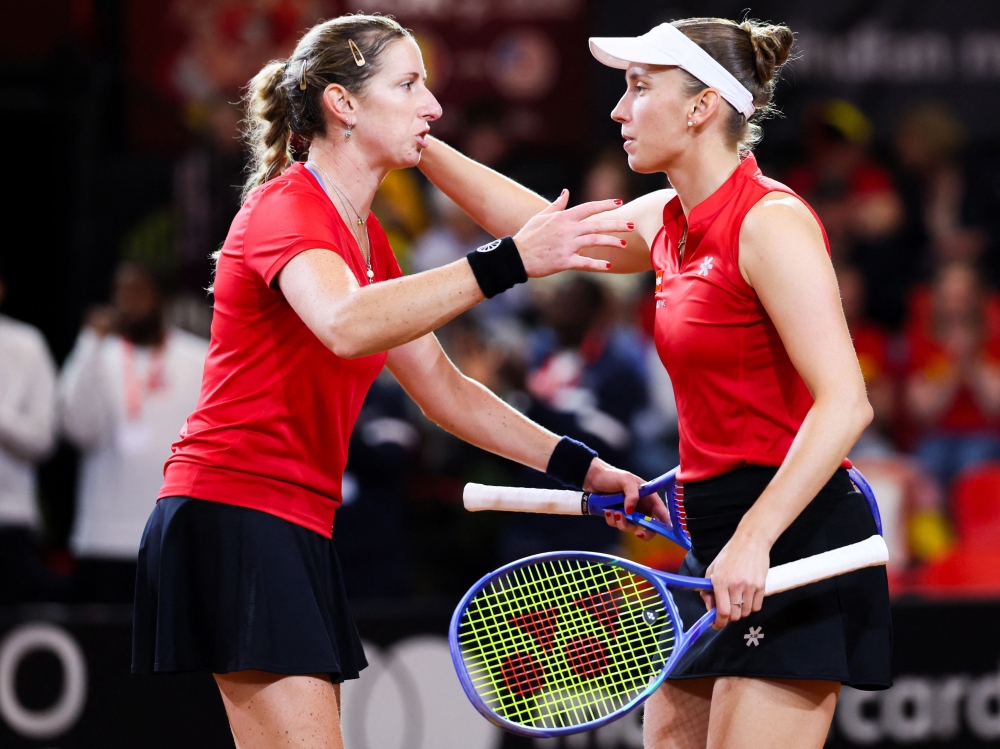 Kempen (L) and Elise cheer each other during their Billie Jean King Cup play-off tennis doubles match against the US