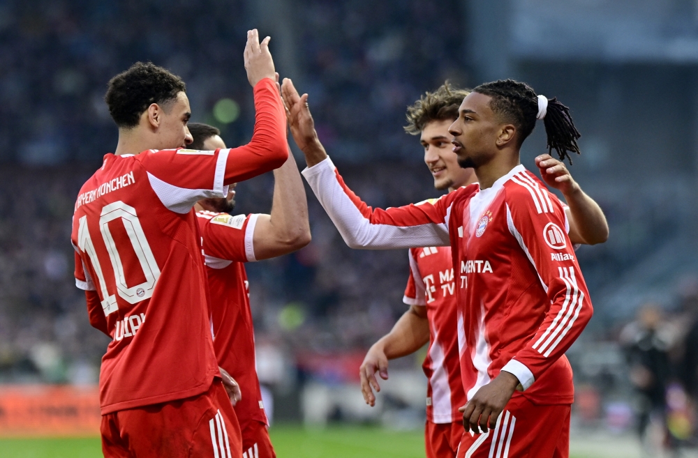  Bayern Munich's Michael Olise celebrates scoring their third goal with teammates 