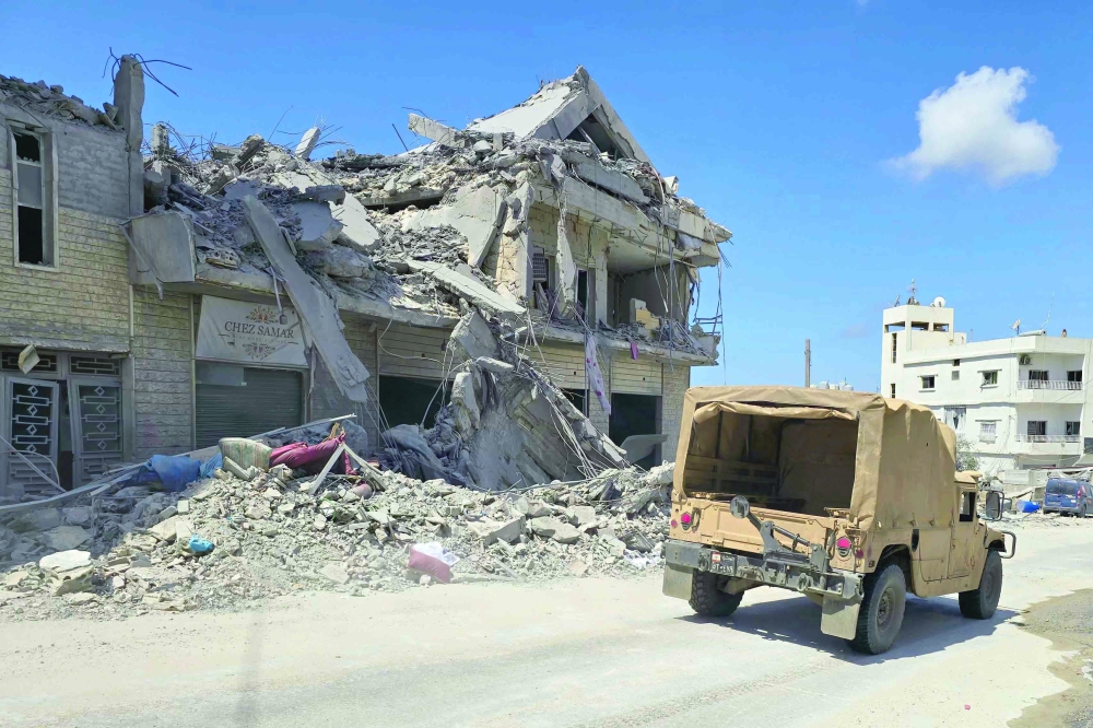 A jeep drives past a destroyed building at the site of an Israeli strike that targeted the southern Lebanese village of Al Bazouriyah. — AFP