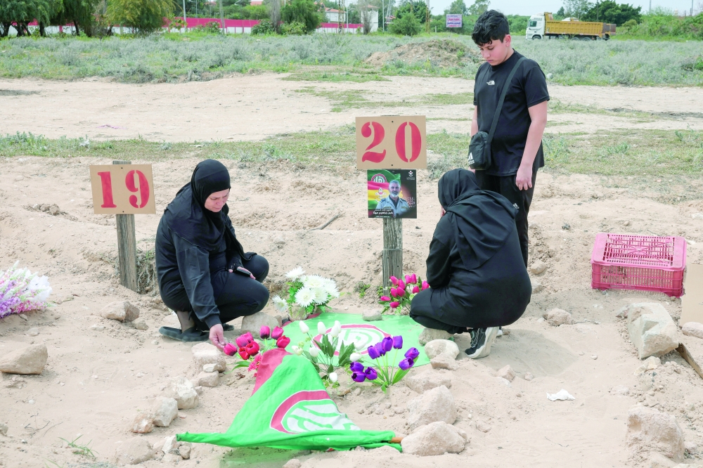 A family mourns their relative at a temporary graveyard in Tyre, south Lebanon. — Reuters 
