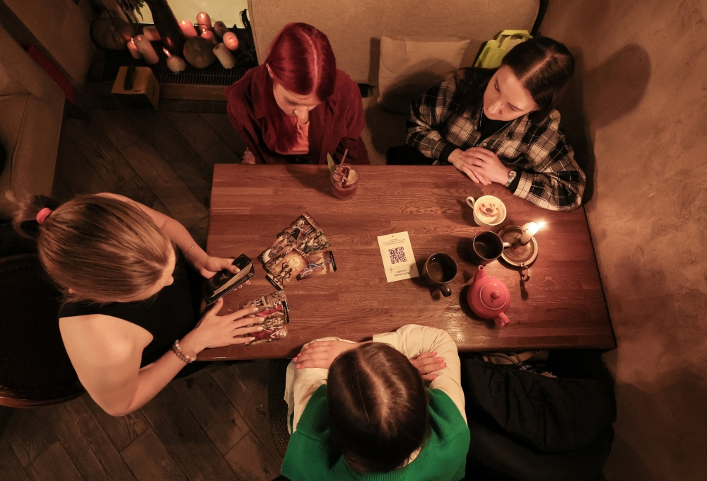 Fortune teller Arina Frants lays out Tarot cards on a table in the voodoo-themed bar Marie Laveau in Moscow, Russia February 17, 2026.