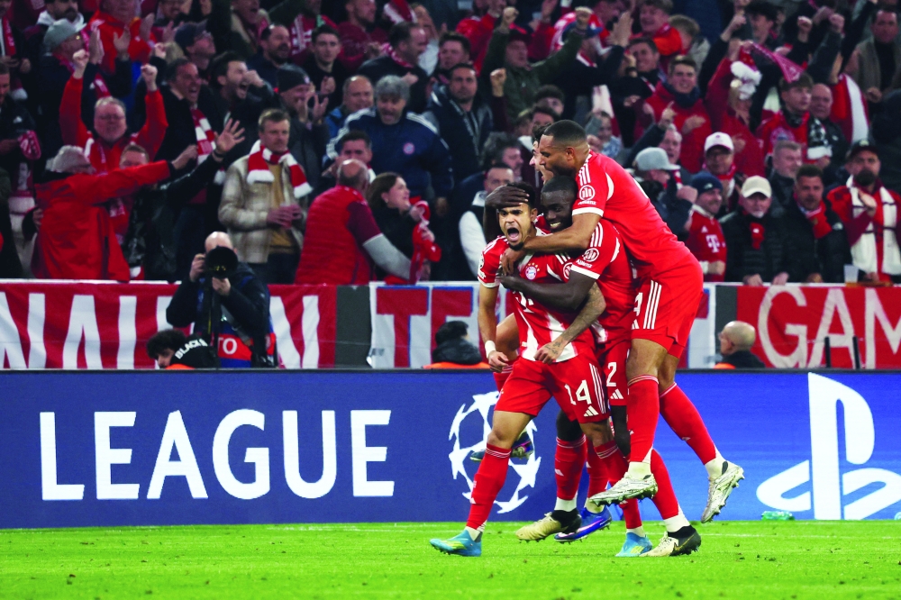 Bayern Munich's Colombian forward #14 Luis Diaz (L) celebrates with teammates after scoring the equalising 3-3 goal during the Uefa Champions League quarterfinal second leg match against Real Madrid in Munich, southern Germany. — AFP
