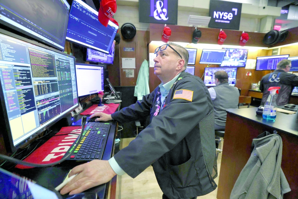 Traders work on the floor of the New York Stock Exchange at the opening bell in New York. — AFP
