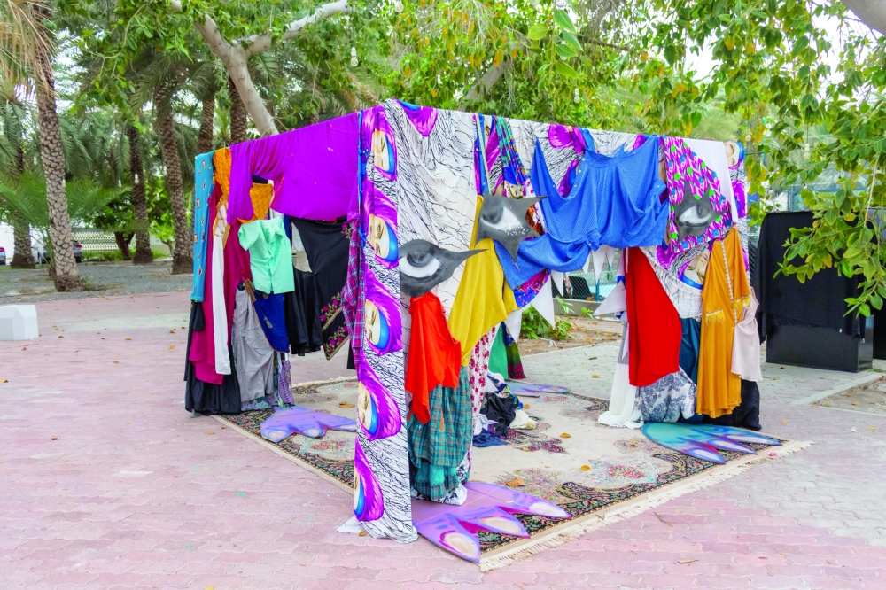 Art installation created by Al Hamdi using piles of discarded garments, offering a visual representation of the scale of textile waste generated by the fashion industry.