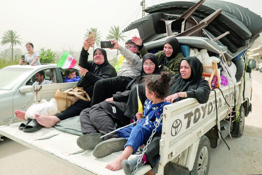Displaced people make their way back to their homes, in Qasmiyeh, Lebanon. — Reuters