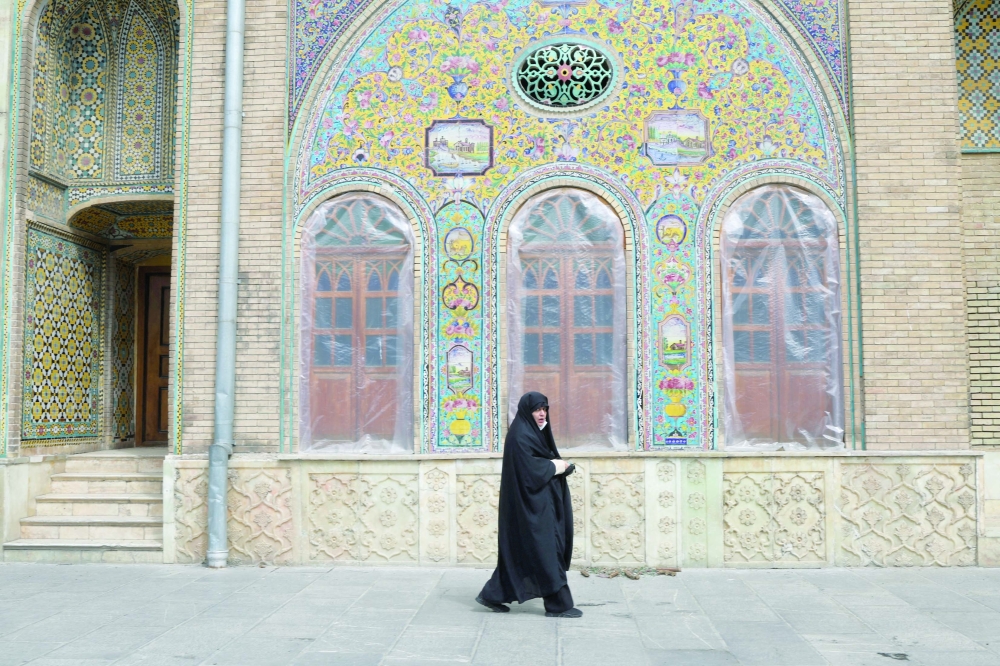 A woman walks past windows covered with plastic at Golestan Palace, a Unesco World Heritage site, in Tehran. — Reuters