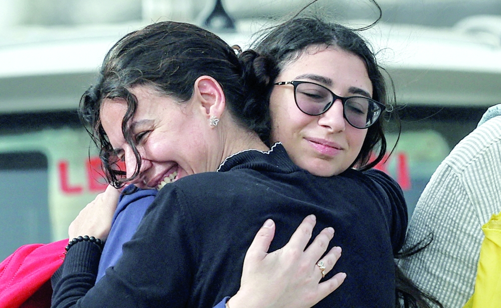 A family reunites after crossing the bridge linking southern Lebanon to the rest of the country, which was hit earlier in an Israeli strike, after a 10-day ceasefire between Lebanon and Israel went into effect. — Reuters