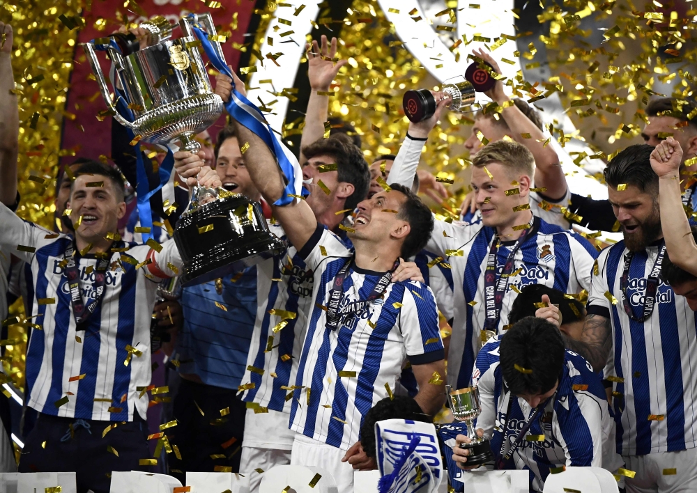 Real Sociedad's Spanish forward #10 Mikel Oyarzabal (C) and teammates celebrate with the trophy  