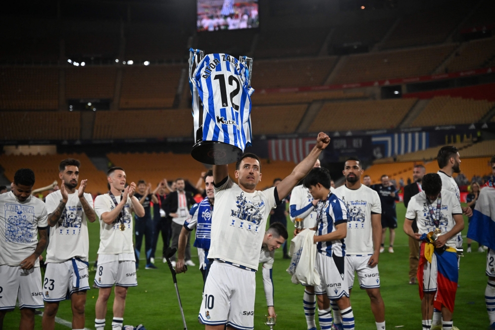 Real Sociedad's Spanish forward #10 Mikel Oyarzabal (C) and teammates celebrate with the trophy  