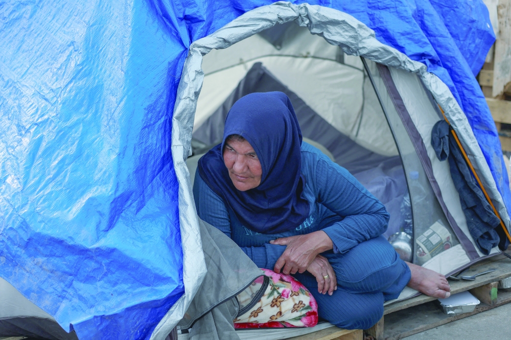 A displaced woman sits inside her tent at a makeshift encampment in Beirut. — Reuters