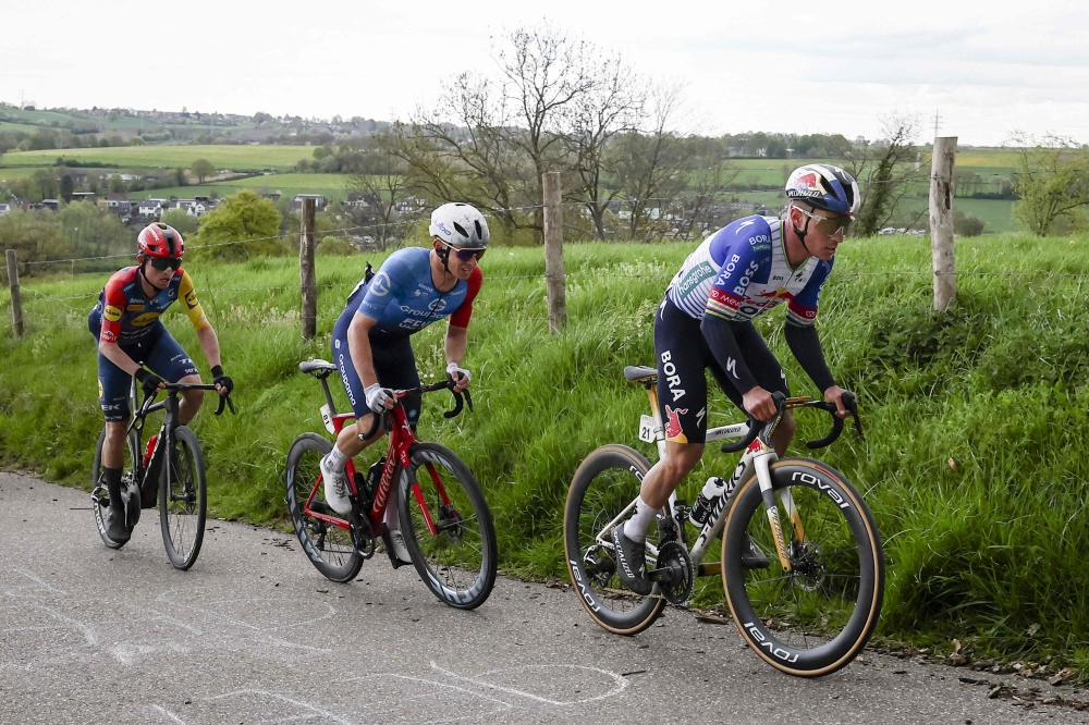 hansgrohe team's Belgian rider Remco Evenepoel (R), Groupama - FDJ United team's French rider Romain Gregoire (C) and Lidl - Trek team's Danish rider Mattias Skjelmose cycle  