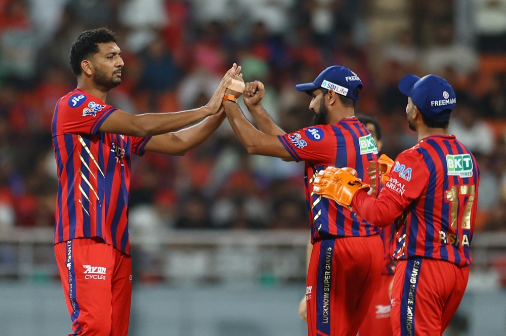   Lucknow Super Giants players celebrate taking the wicket of Punjab Kings' Priyansh Arya 