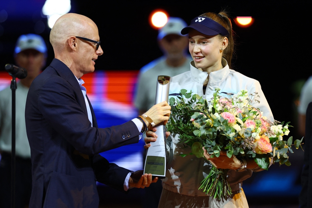   Porsche CEO Michael Leiters presents Kazakhstan's Elena Rybakina the trophy after winning her women's singles final against Czech Republic's Karolina Muchova  