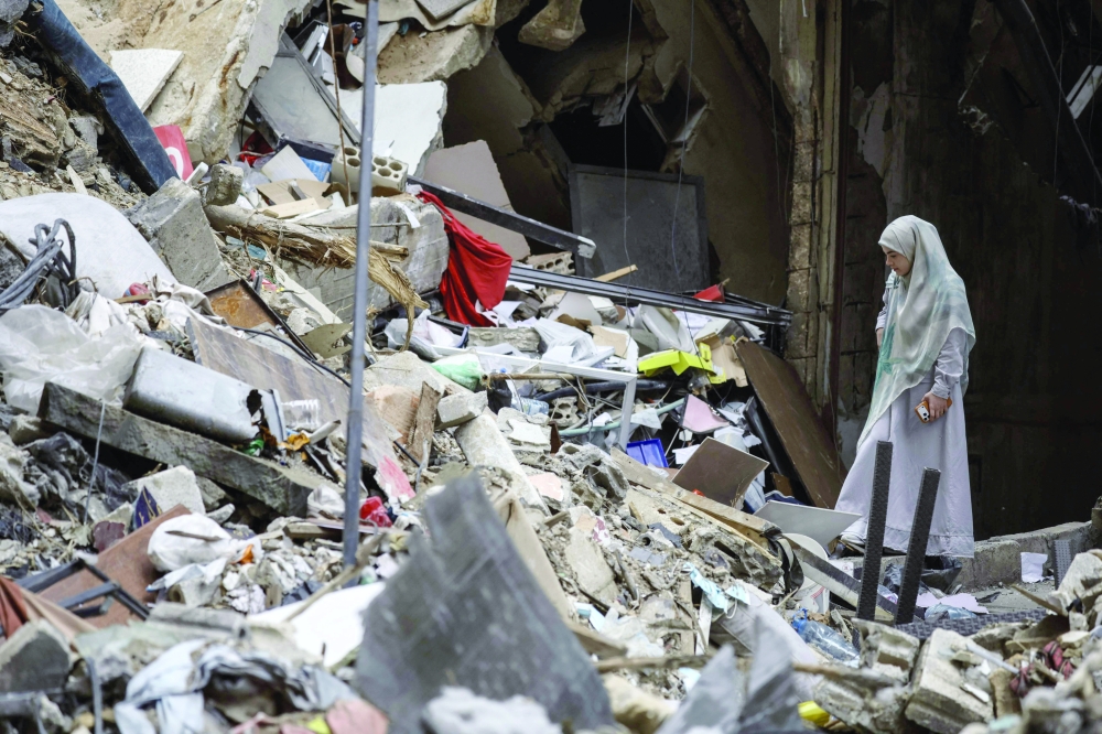 A woman stands amid the debris of a destroyed building in the Haret Hreik area of Beirut on Monday. — AFP