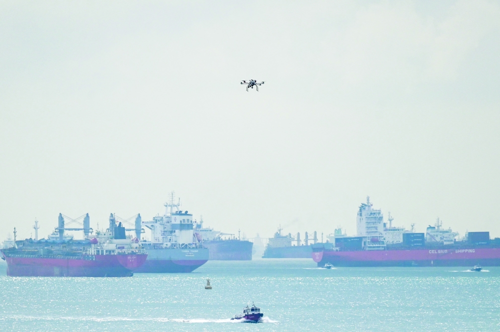 This picture shows vessels anchored as a drone flies along the Singapore straits eastern anchorage in Singapore on April 21, 2026. (Photo by Roslan RAHMAN / AFP)