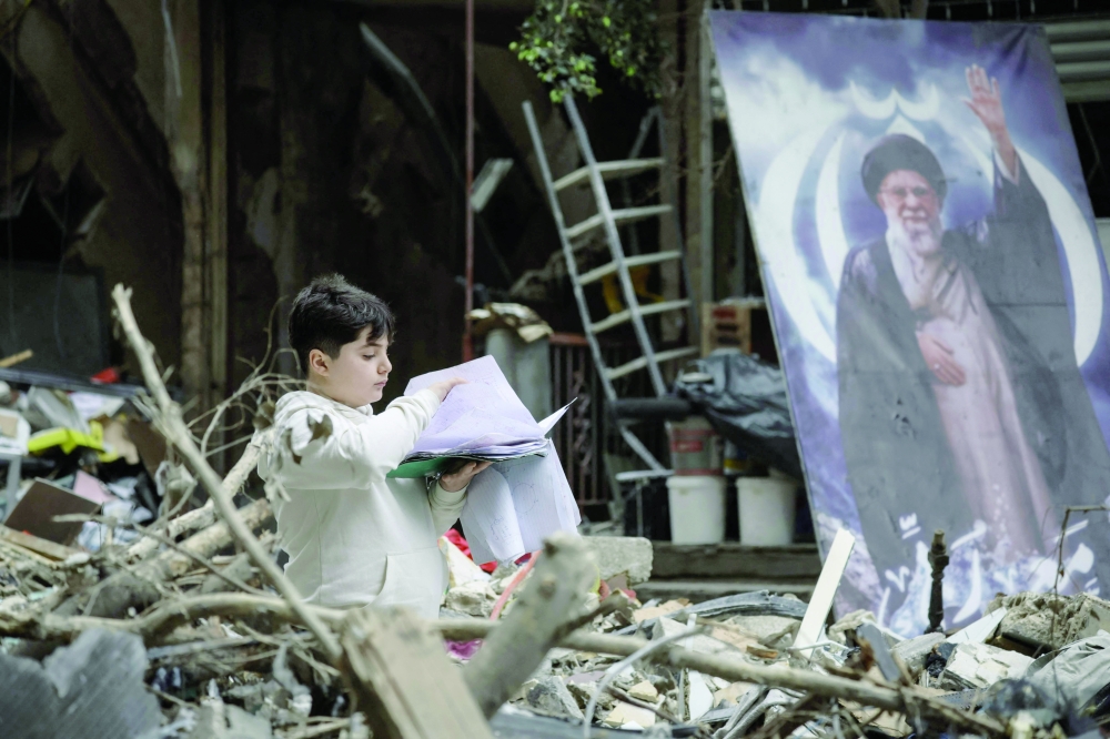 A boy stands amid the debris of a destroyed building in the Haret Hreik area of Beirut southern suburbs. — AFP