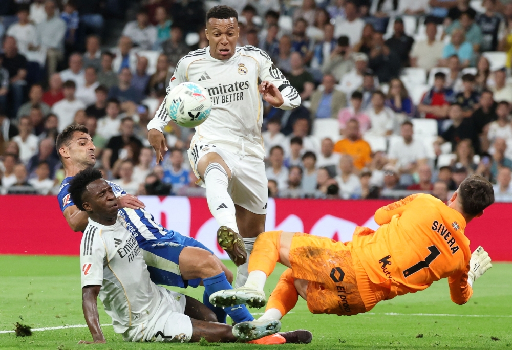 Real Madrid's French forward #10 Kylian Mbappe challenges Alaves' Spanish goalkeeper #01 Antonio Sivera  
