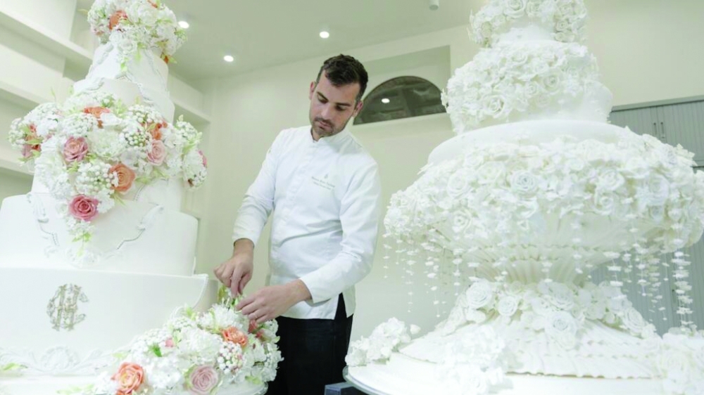 French pastry chef Bastien Blanc-Tailleur decorates a wedding cake at his studio. — AFP