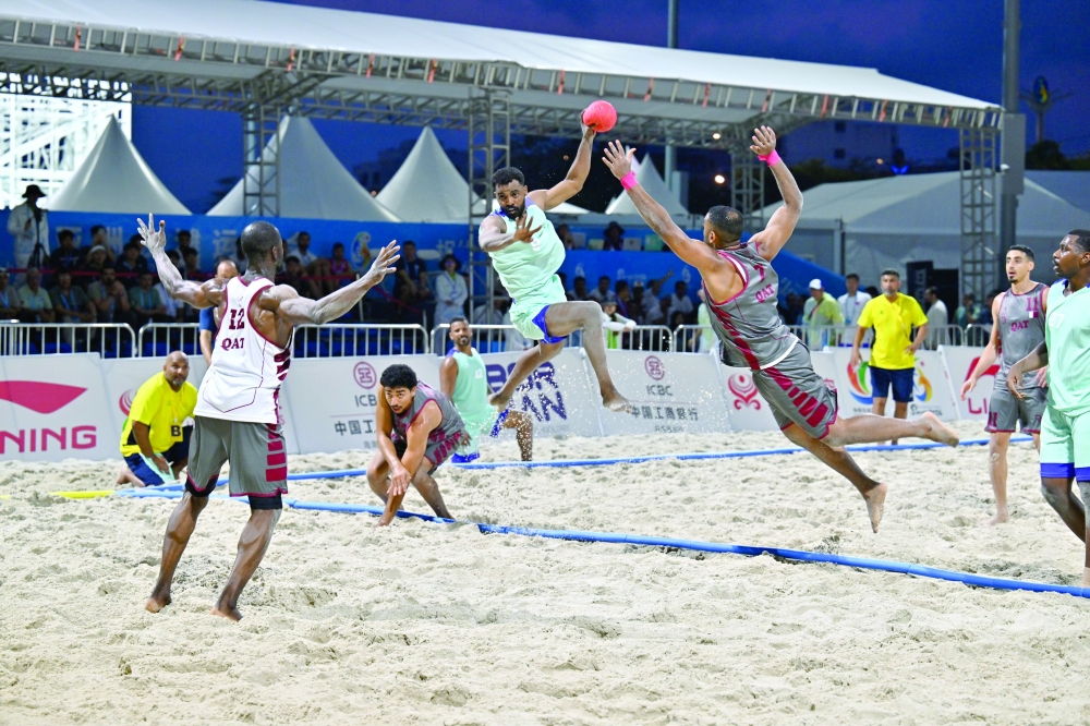 Oman and Qatar players in action during the beach handball match.