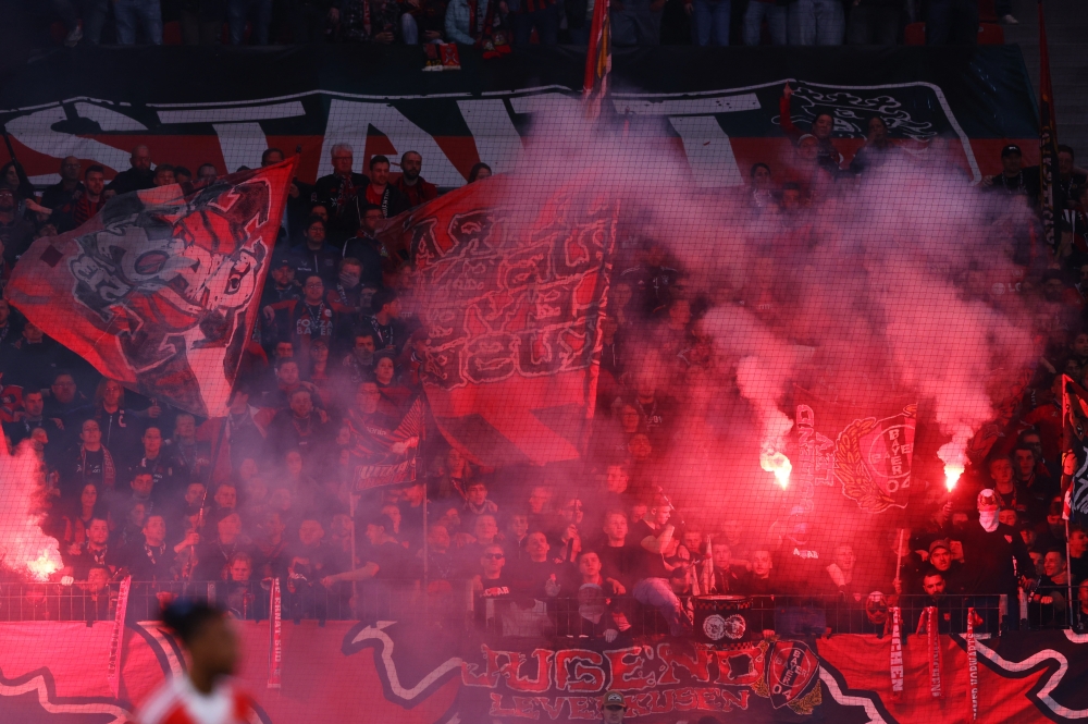 Bayer Leverkusen fans with flags and flares in the stands  