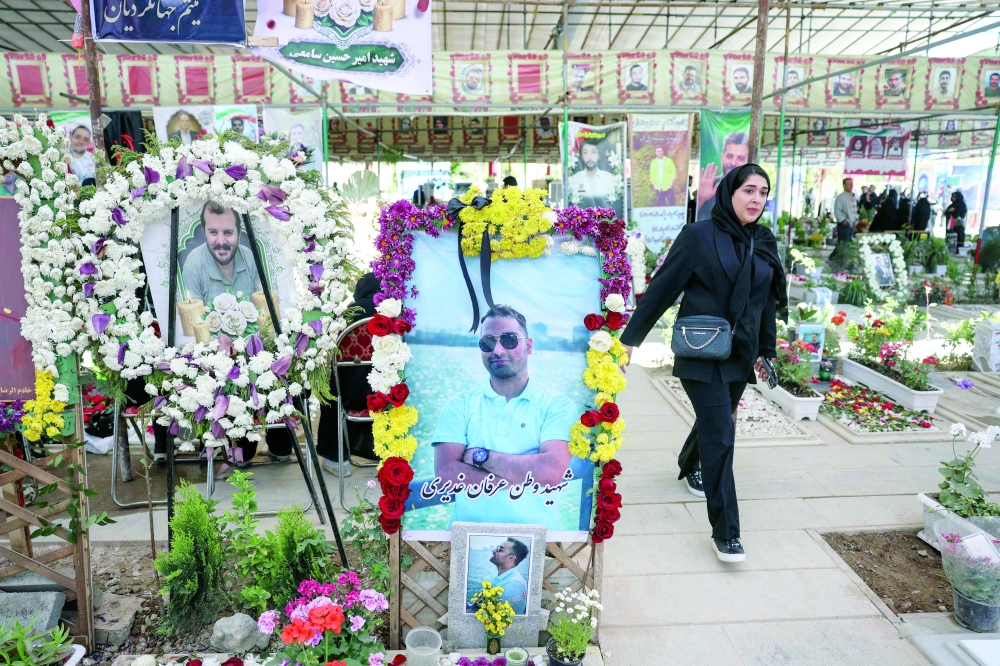 A woman walks past the graves of people killed during the US-Israeli war against the Islamic republic at the Behesht Zahra Cemetery in Tehran on Thursday. — AFP 