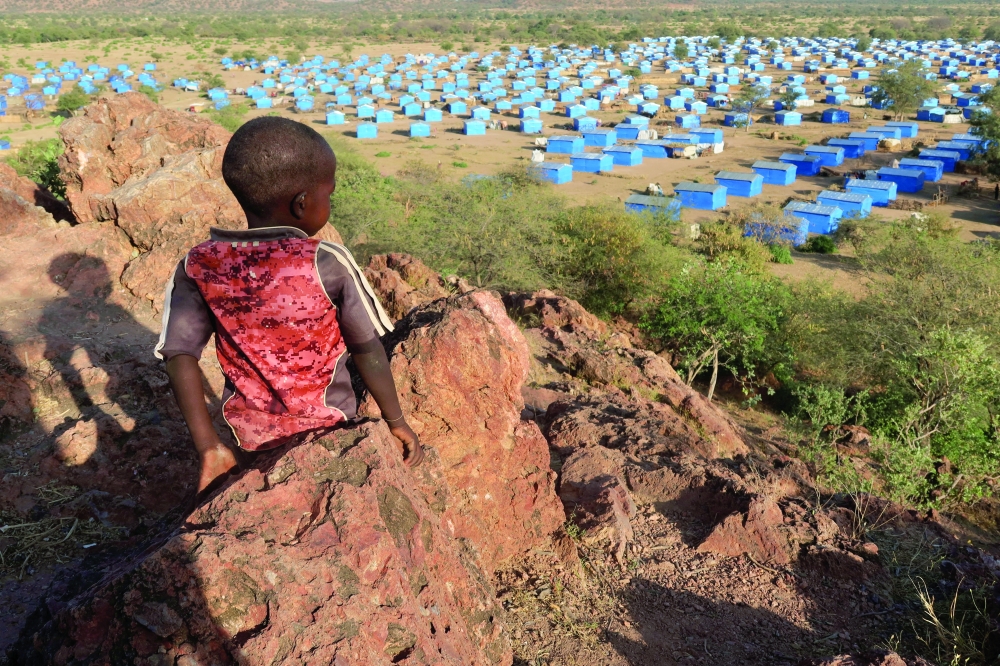 A boy sits atop a hill overlooking a refugee camp near the Chad-Sudan border. — Reuters file photo