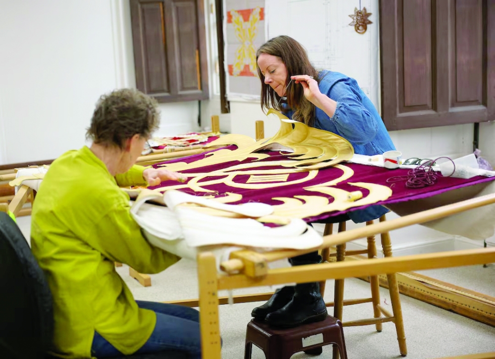 Senior studio embroiderer Helen Stevens and Marg Dier hand‑stitch the royal cypher of Britain's King Charles for the new Royal Opera House stage curtains. — Reuters