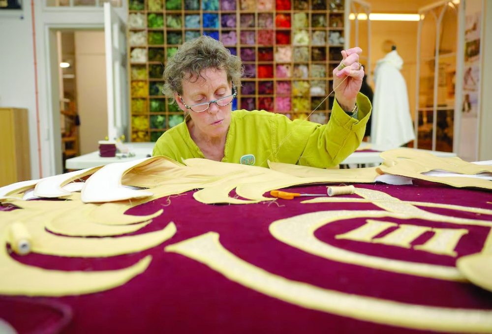 Senior studio embroiderer Helen Stevens hand‑stitches the royal cypher of Britain's King Charles for the new Royal Opera House stage curtains at the Royal School of Needlework. — Reuters