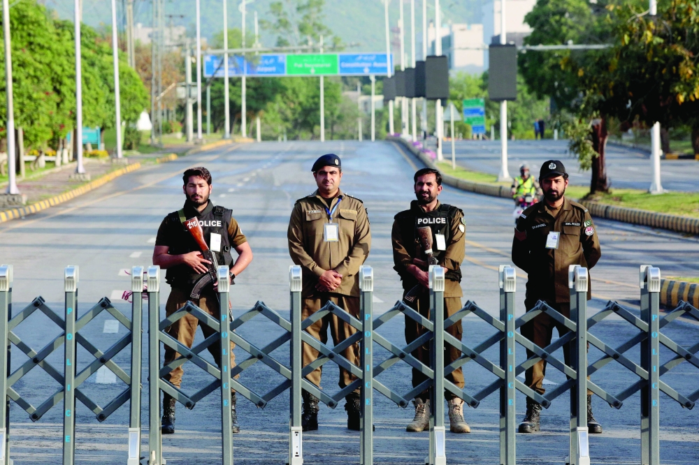 Police officers stand guard behind a barricade near Serena Hotel, in Islamabad. — Reuters file photo 