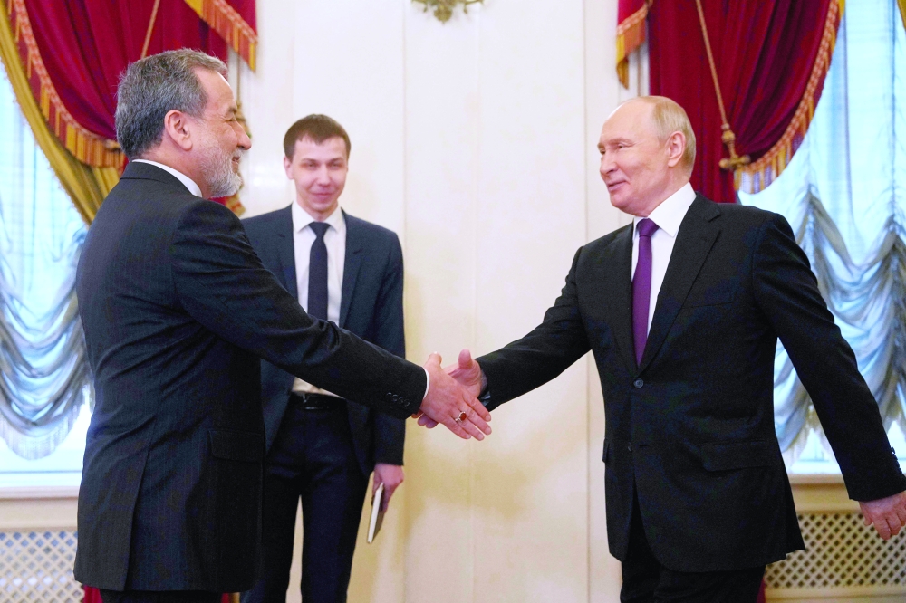 Russian President Vladimir Putin shakes hands with Iranian Foreign Minister Abbas Araghchi, in Saint Petersburg. — AFP