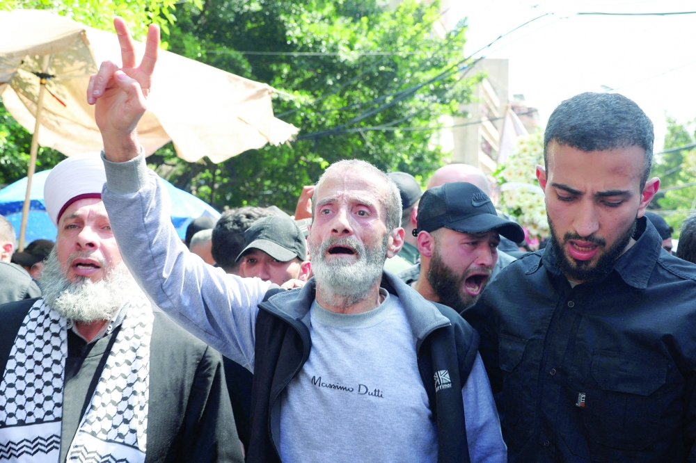 A man attends his his brother and son funeral in Beirut, Lebanon. — AFP