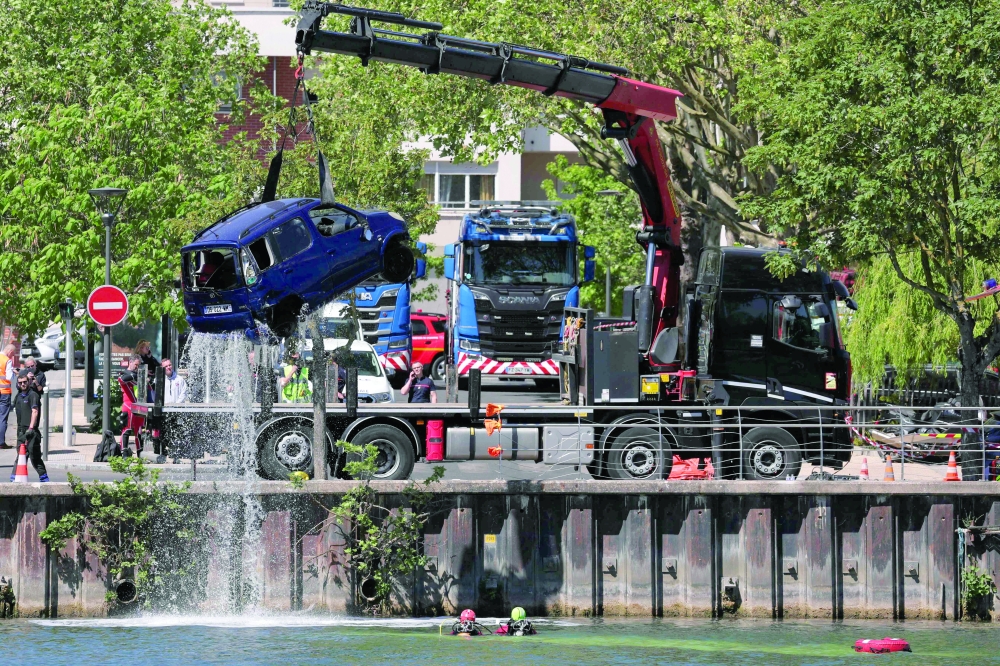 Rescue teams remove a car from the Seine river after a bus with passengers on board crashed into it, both falling into the river, in Juvisy-sur-Orge, on the outskirts of Paris. - AFP
